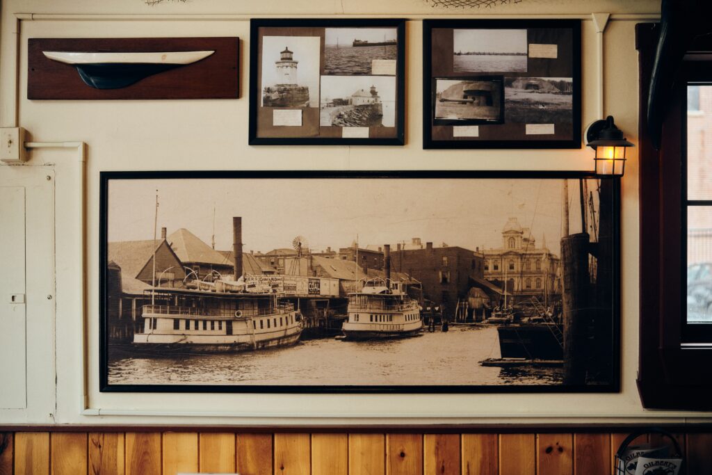 historic photographs of the working waterfront and boats framed on a wall in a chowder house