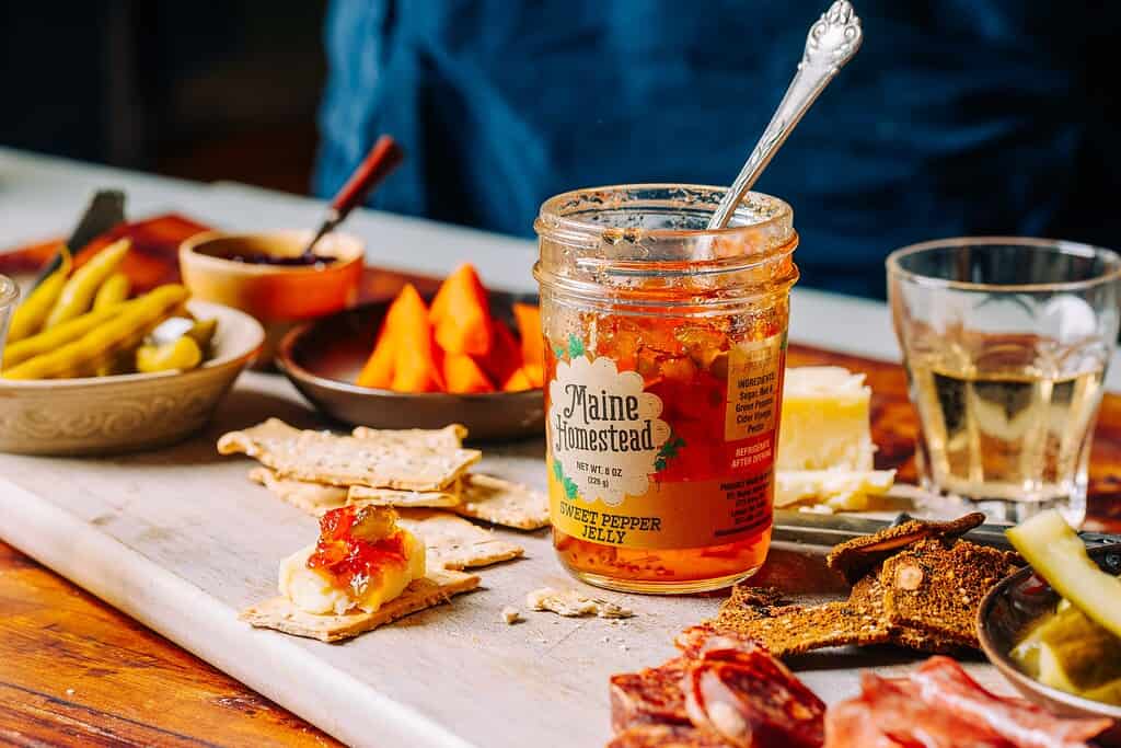 charcuterie board of meat, cheese and crackers with a jar of Maine Homestead jam