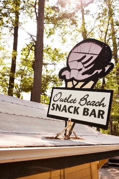 sign shaped in an ice cream cone that says Outlet Beach Snack Bar