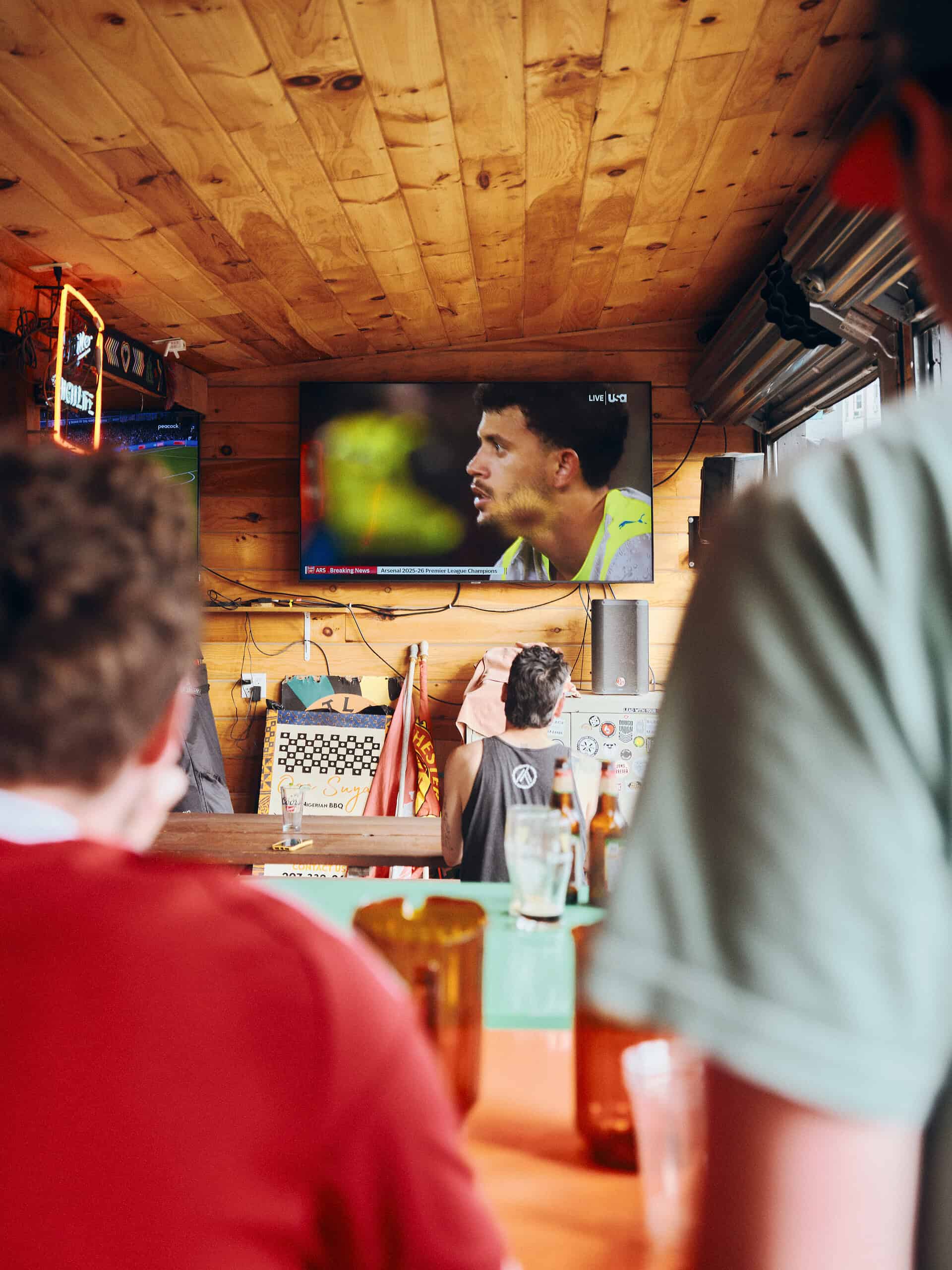 people in a rustic bar watching sports on tv
